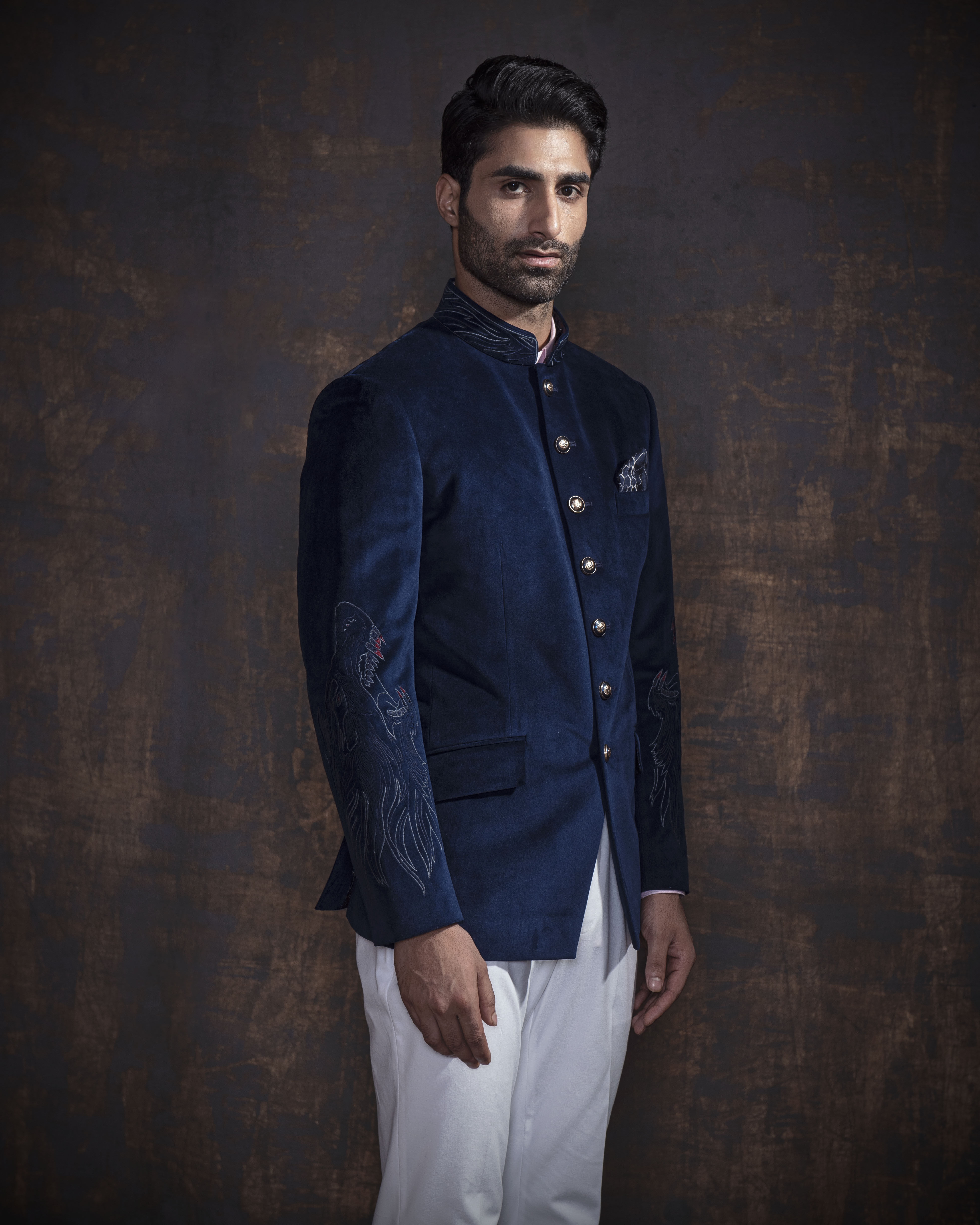 Royal blue velvet bandgala jacket with animal embroidery on the sleeves. Paired up with ivory pants and accessorised with antique gold buttons.