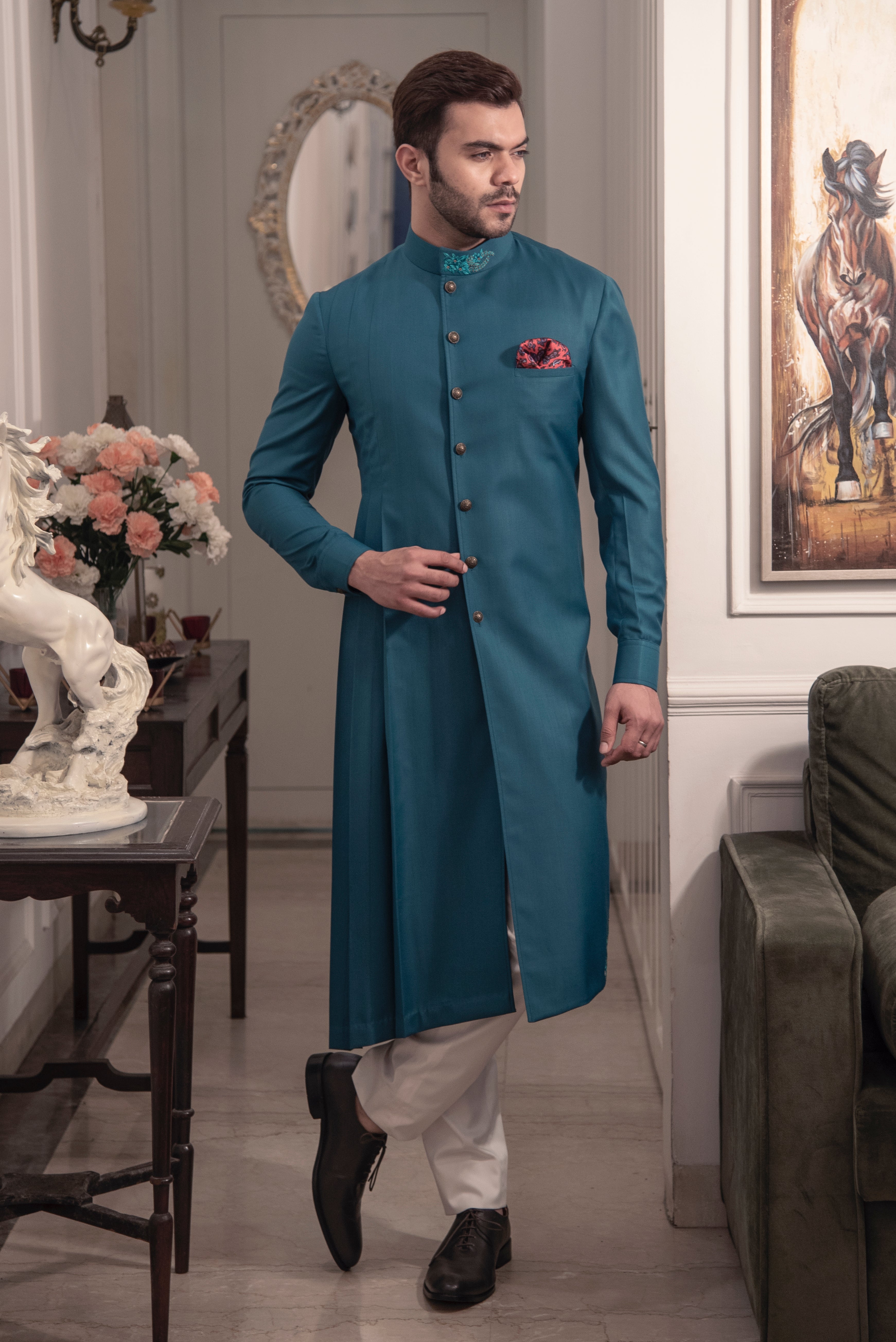 Sea green designer indo cut kurta with self blue coloured embroidery. Paired up with ivory pants.