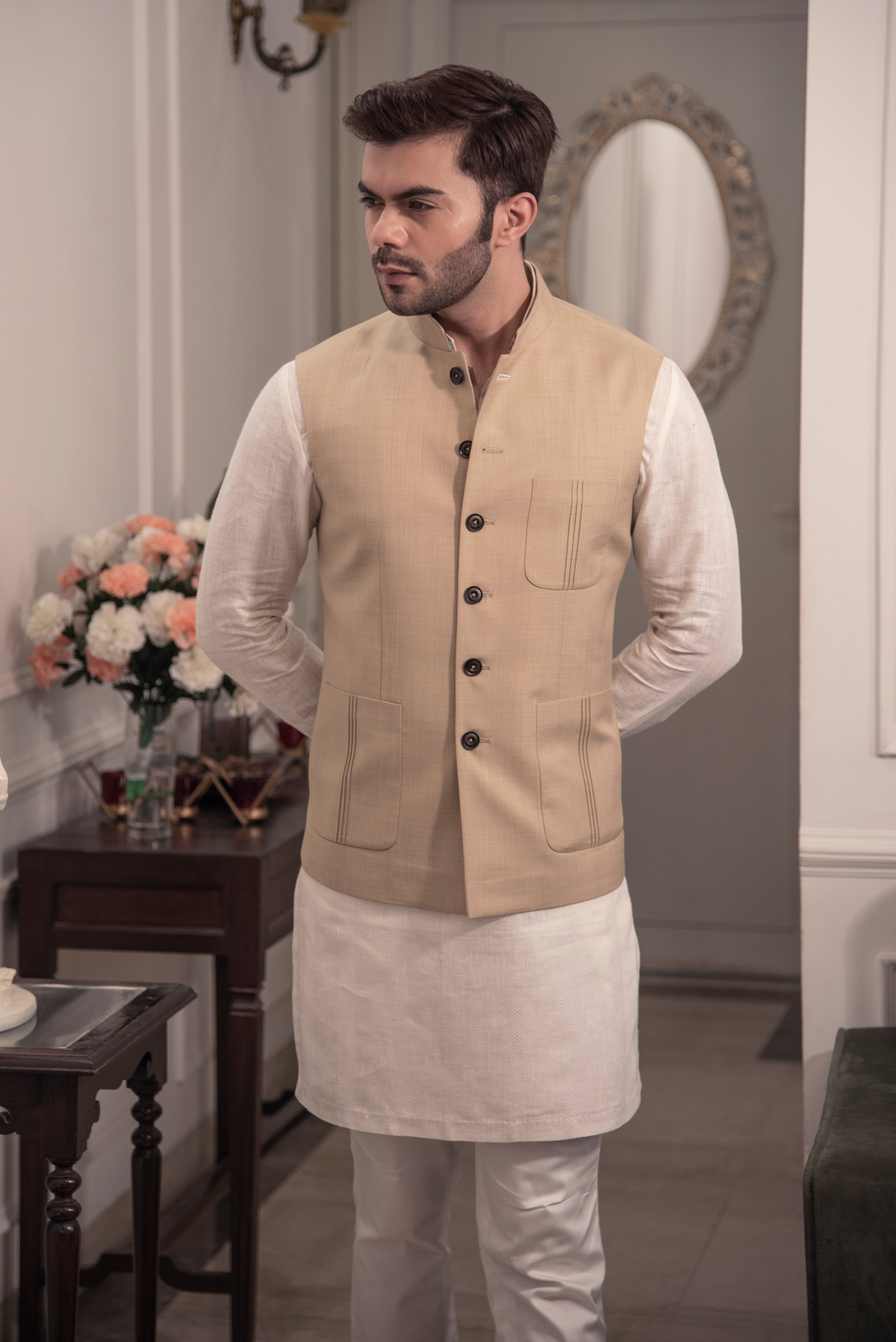 Classic beige nehru jacket. Paired up with off white kurta pajama.