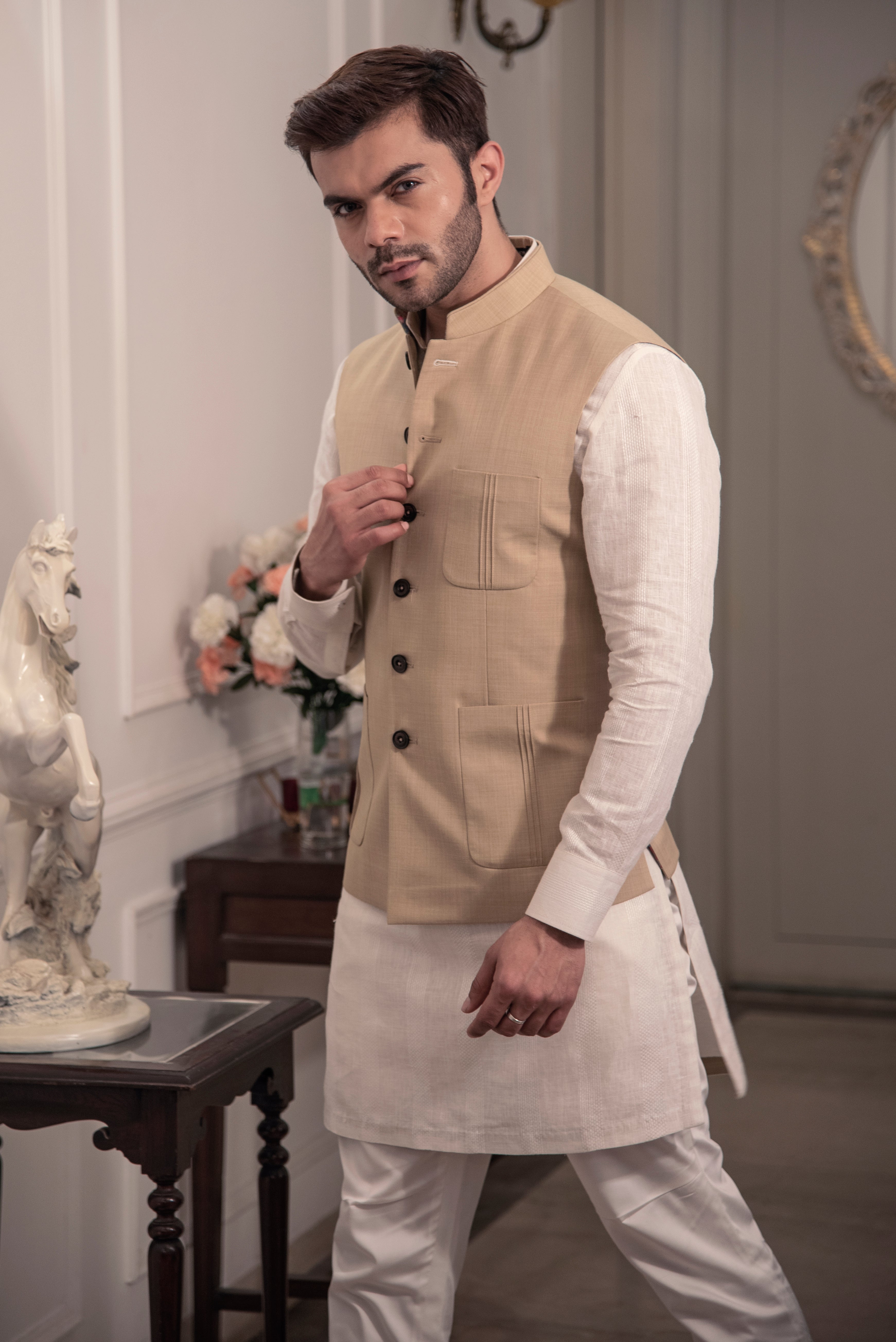 Classic beige nehru jacket. Paired up with off white kurta pajama.