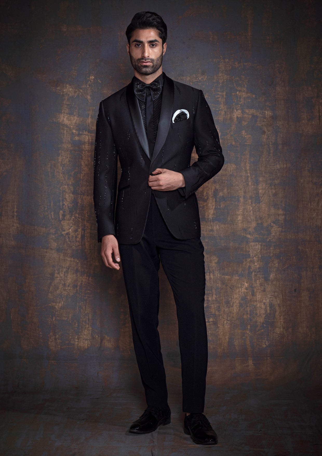 Black self tuxedo with hand embroidery.