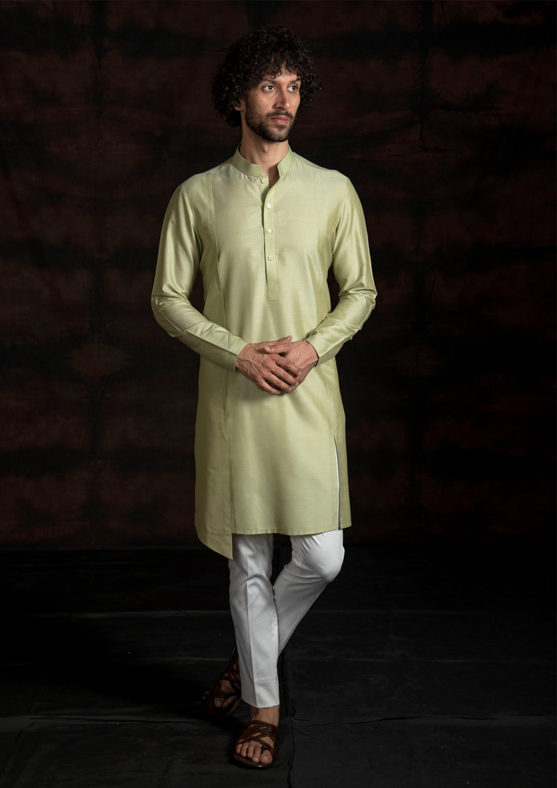 Green asymmetrical kurta with ivory pant pajama.