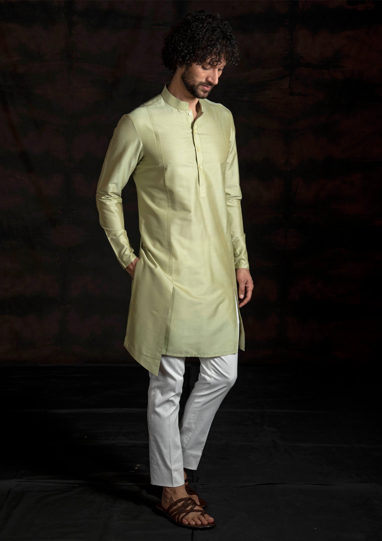 Green asymmetrical kurta with ivory pant pajama.