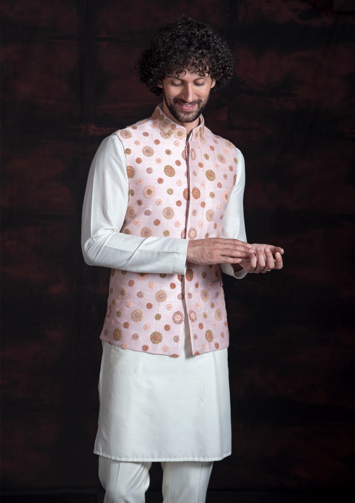 Pink nehru jacket with multicoloured embroidery with off white kurta pajama.