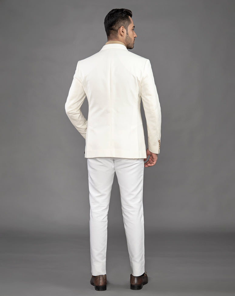 White cotton blazer with peak lapel and embroidered motif on the pocket.