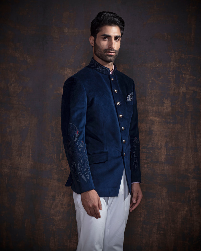 Royal blue velvet bandgala jacket with animal embroidery on the sleeves. Paired up with ivory pants and accessorised with antique gold buttons.