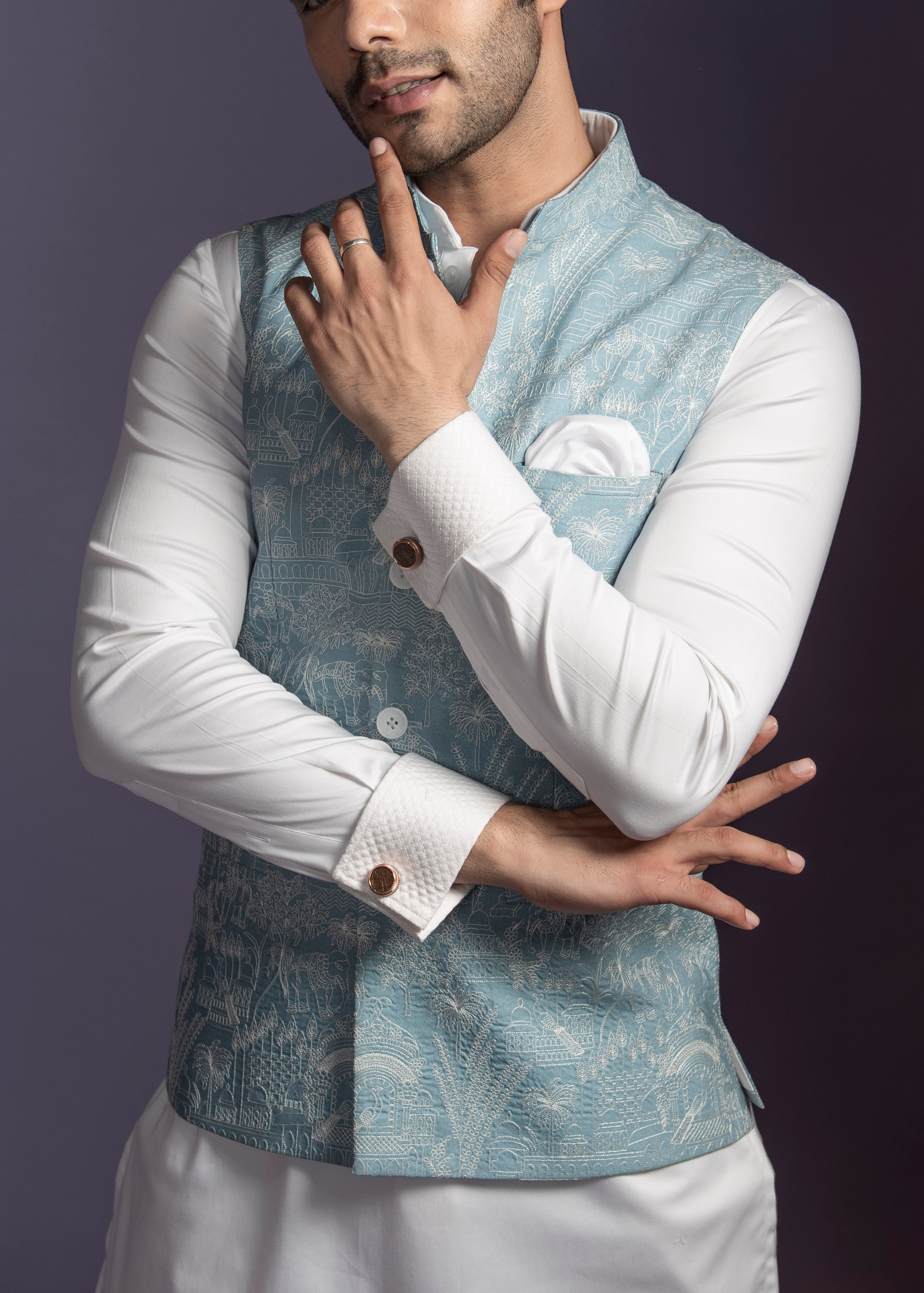 Turquoise blue nehru jackey with off white embroidery paired up with off white kurta pajama.