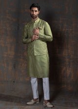 Green self embroidered nehru jacket.  Paired up with Green kurta and ivory pajama.