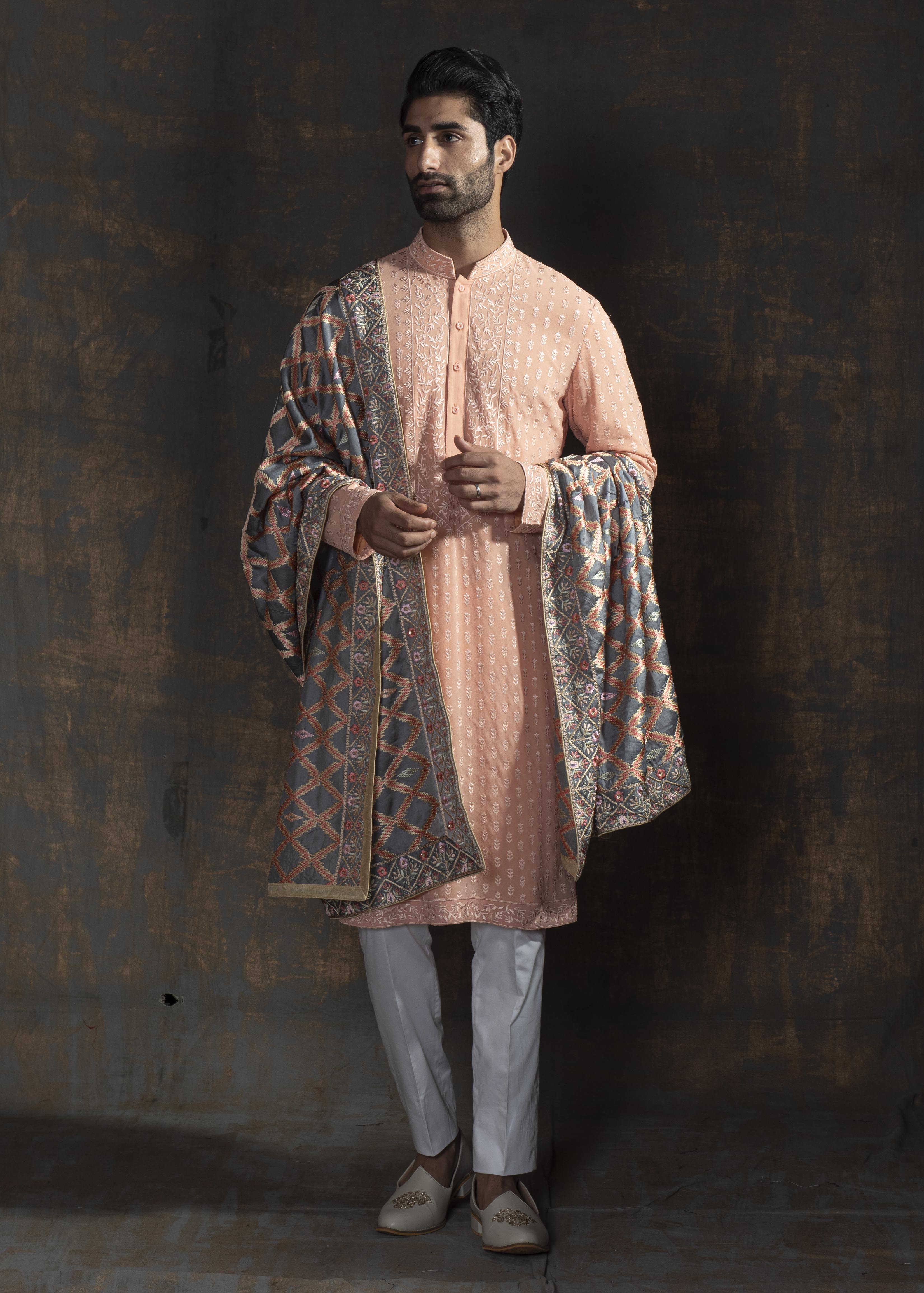 Rustish orange embroidered kurta paired up with ivory pant pajama.