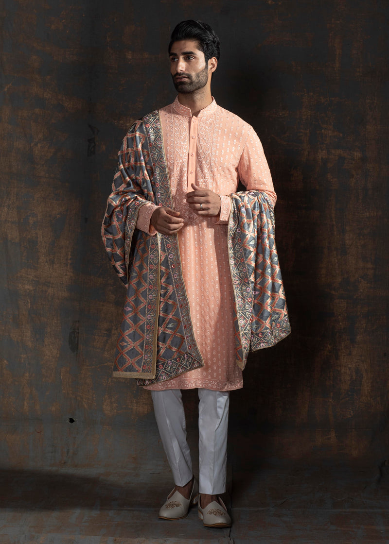 Rustish orange embroidered kurta paired up with ivory pant pajama.