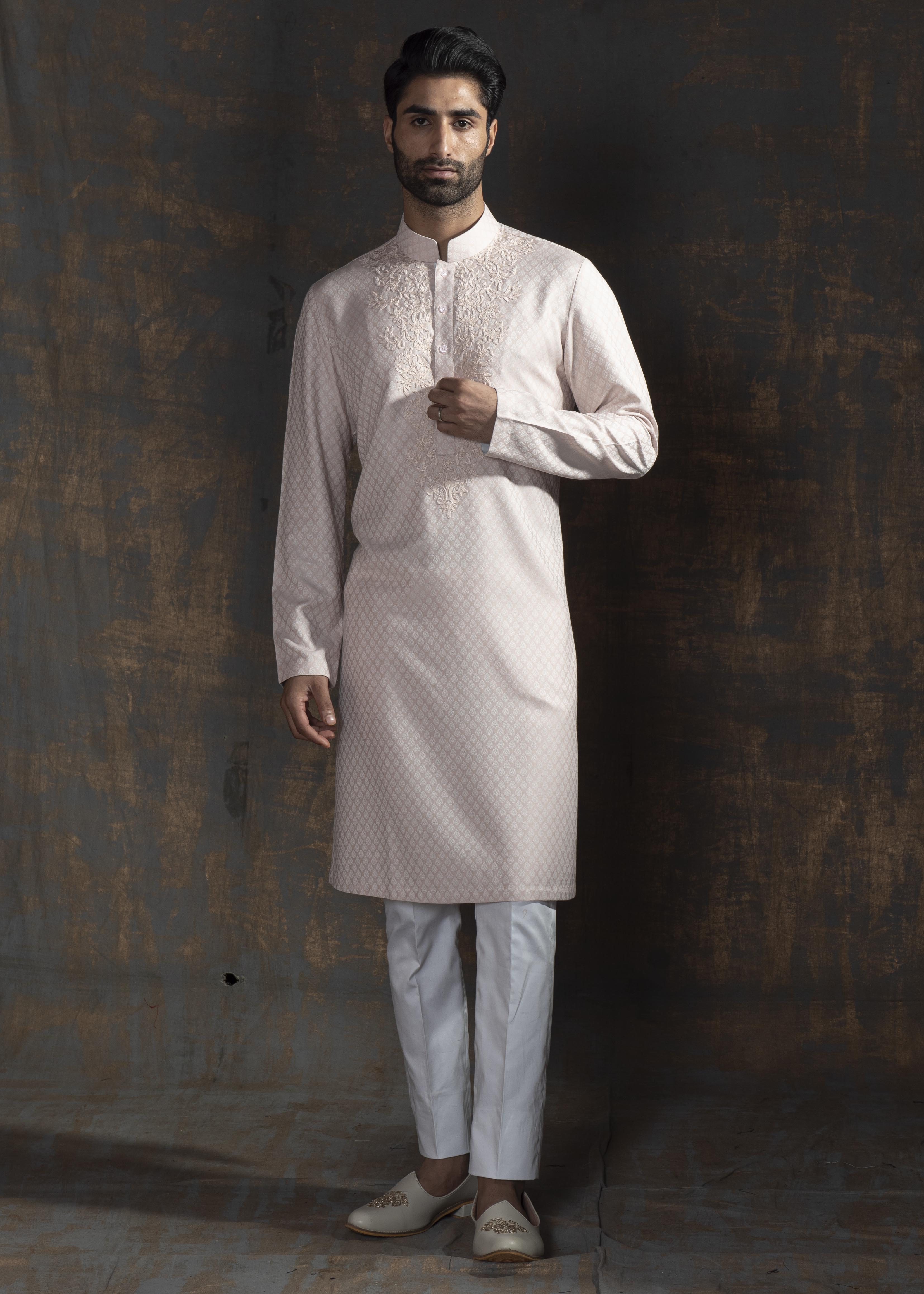 Pink self printed kurta with ivory embroidery on the neck. Paired up with ivory pant cut pajama.