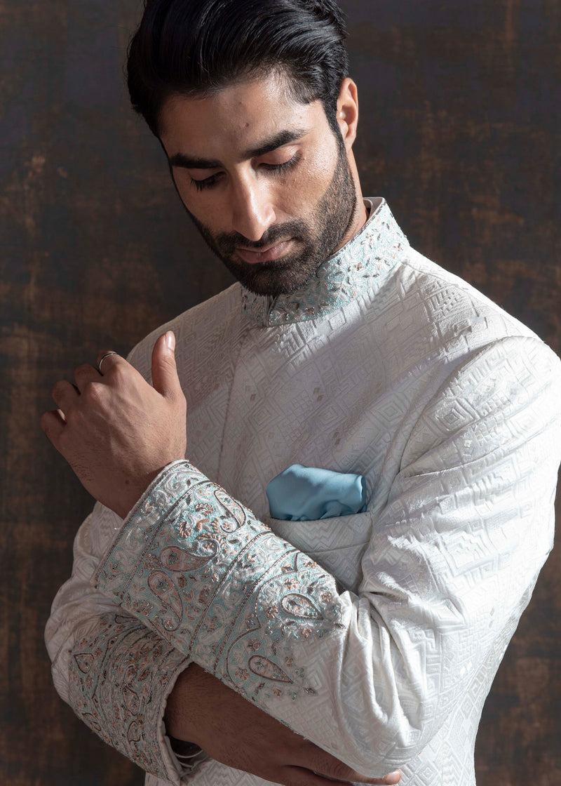 White self embroidered sherwani with off white kurta pajama.