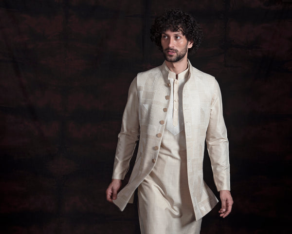 Beige embroidered long nehru jacket with beige kurta and chooridar.