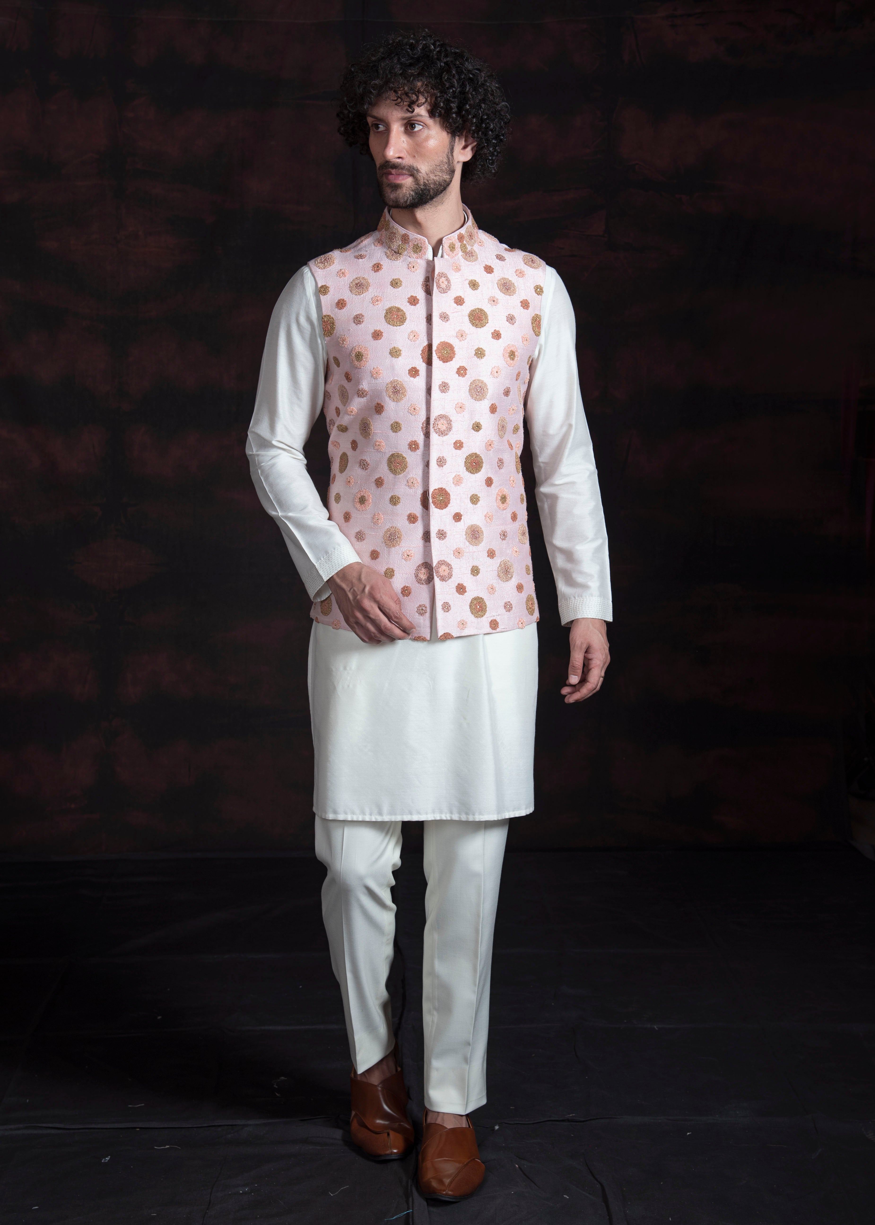 Pink nehru jacket with multicoloured embroidery with off white kurta pajama.