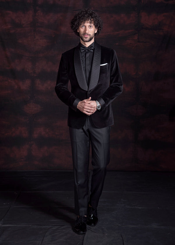 Black velvet tuxedo with broad shawl lapel and hand embroidery on the lapel. Paired up with jet black pants.