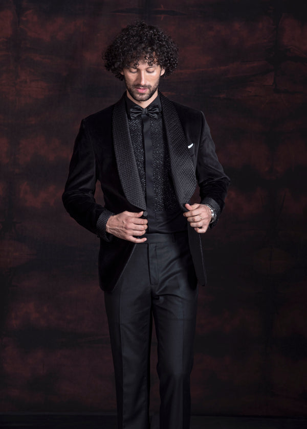 Black velvet tuxedo with broad shawl lapel and hand embroidery on the lapel. Paired up with jet black pants.