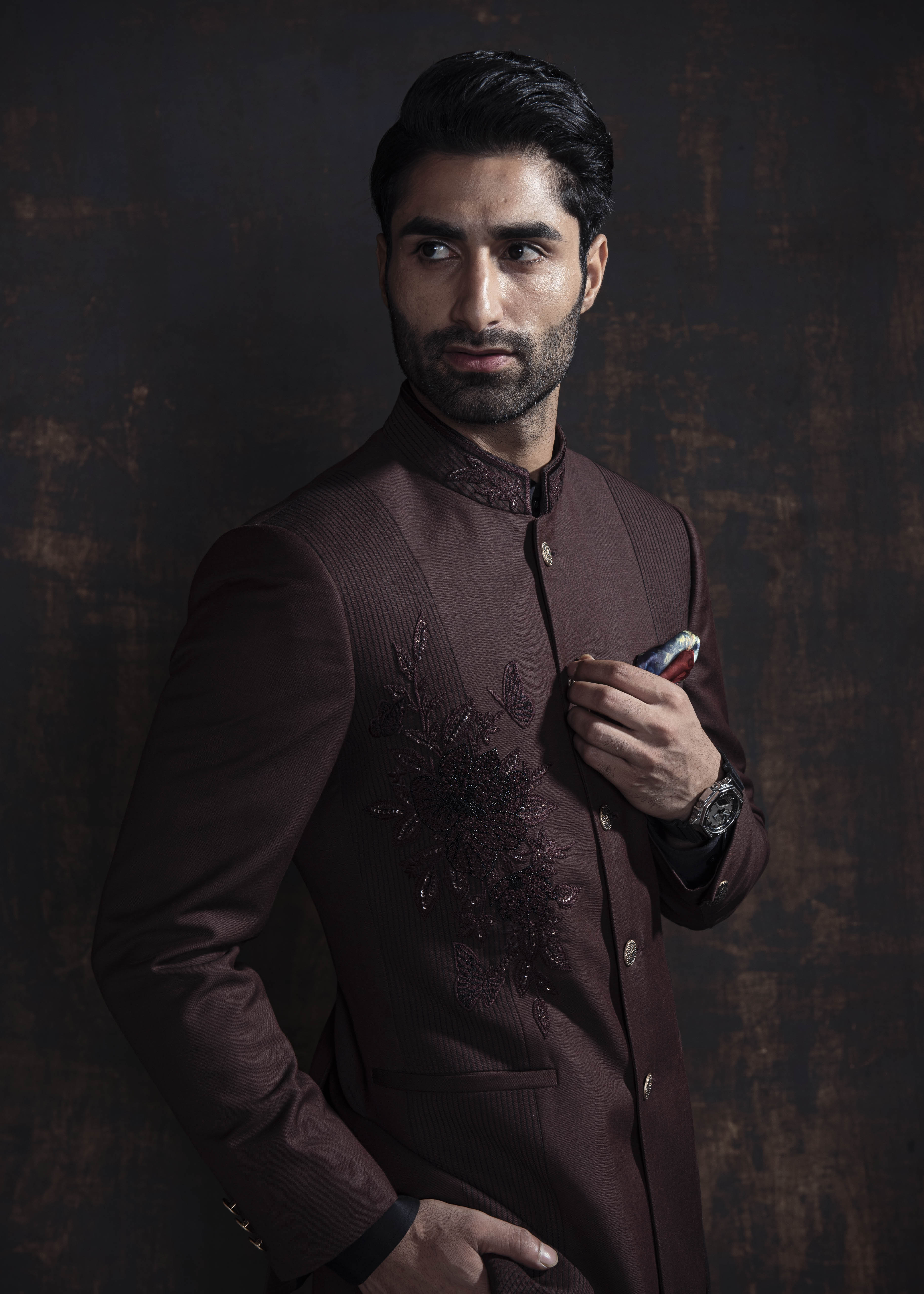 Brown designer, asymmetrical bandgala jacket with black vertical thread work and self on self embroidery. Paired up with jet black pants.