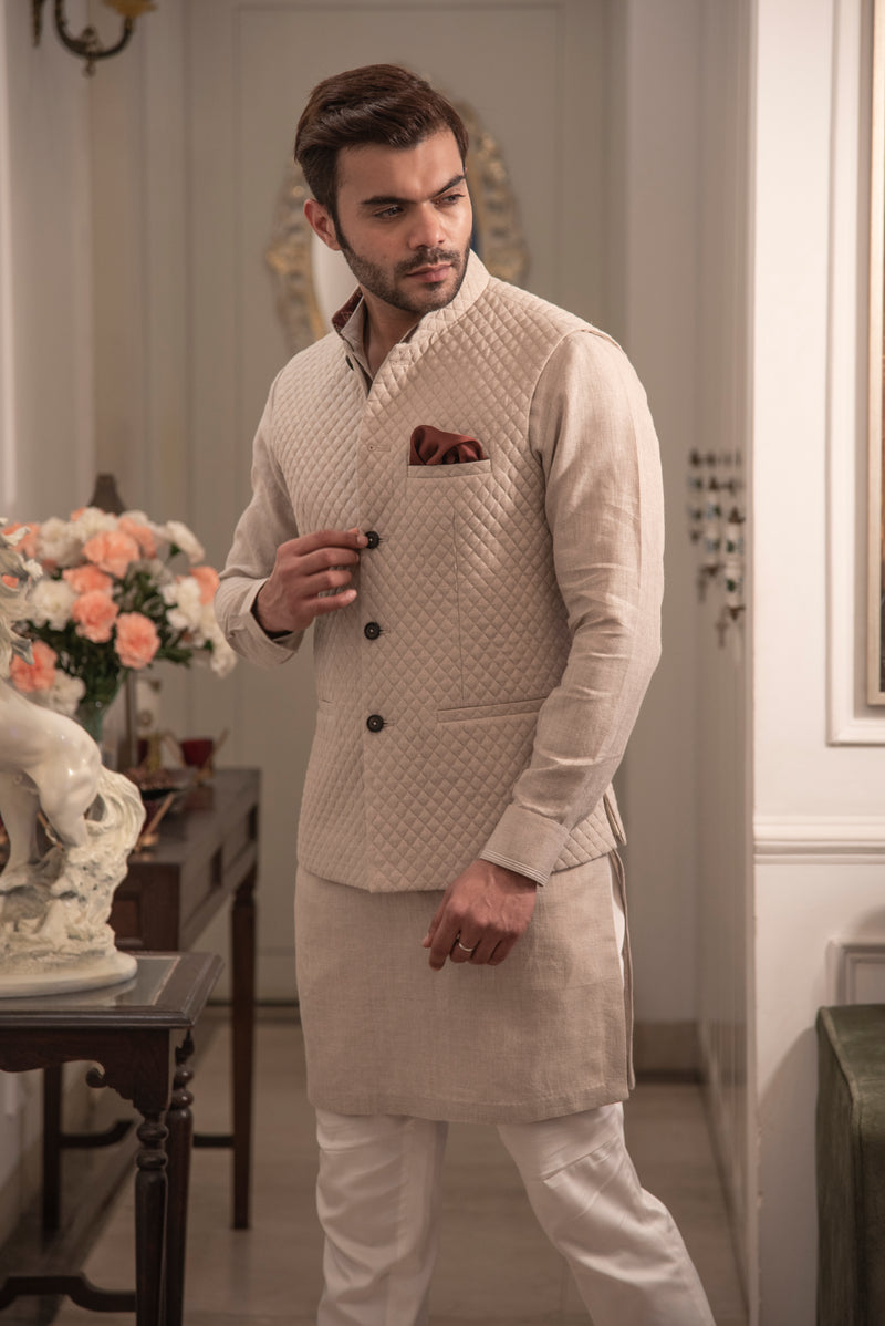 Beige coloured quilted nehru jacket in linen fabric with same linen kurta and off white pant cut pajama.