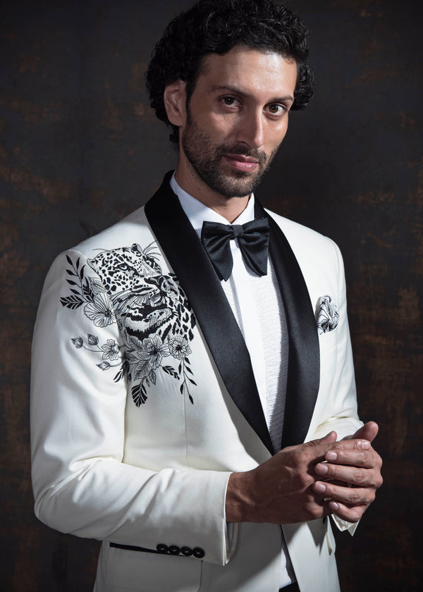 White tuxedo jacket with animal embroidery. Paired up with jet black pants.