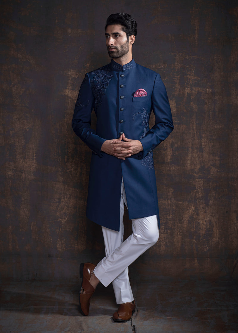 Blue asymmetrical Indo Western with thread work and self on self embroidery. Paired up with off white pant cut pajama.