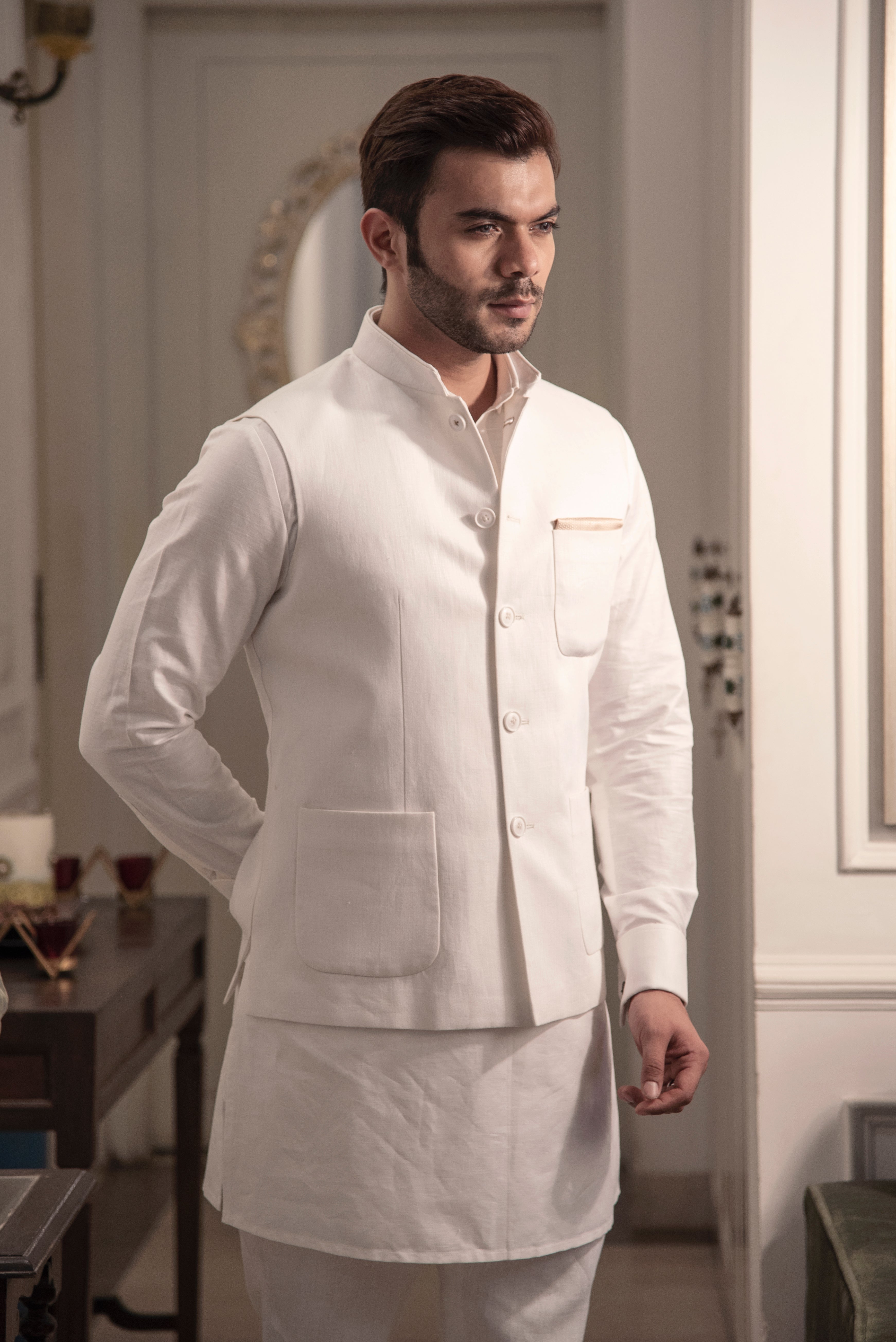 Ivory classic nehru jacket with patch pockets. Paired up with off white kurta pajama.