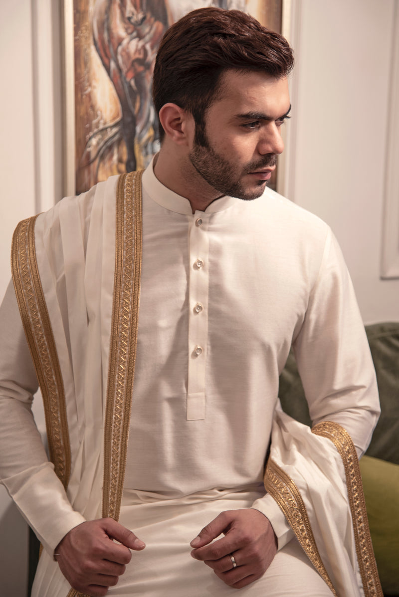 White kurta with white chooridar and white and gold embroidered stole.