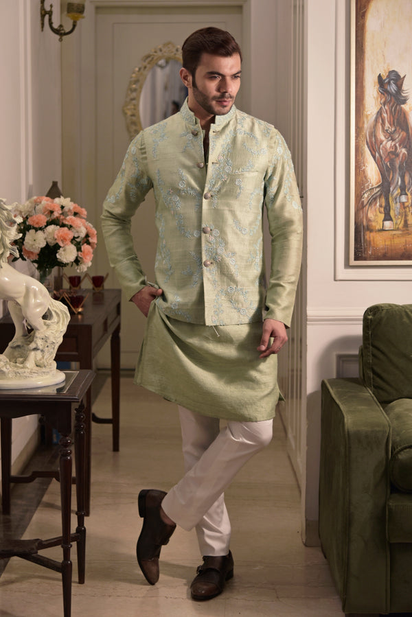 Green raw silk nehru jacket with embroidery. Paired up with green silk kurta and off white pant pajama.