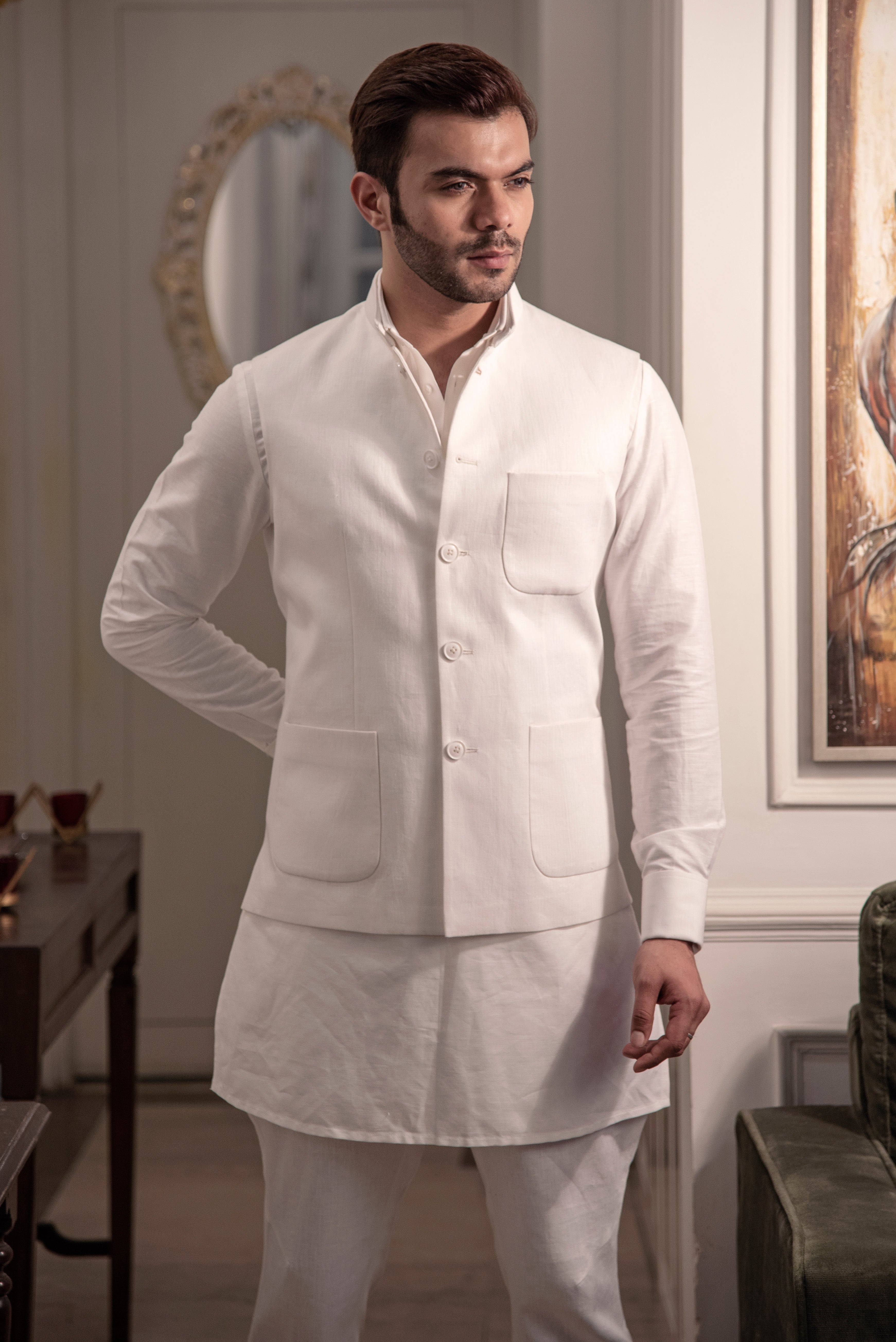 Ivory classic nehru jacket with patch pockets. Paired up with off white kurta pajama.