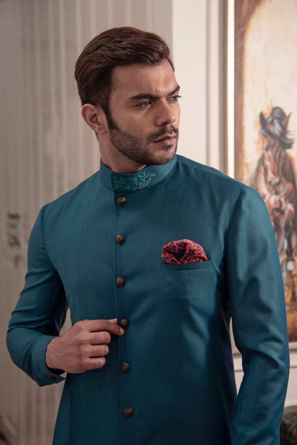 Sea green designer indo cut kurta with self blue coloured embroidery.  Paired up with ivory pants.