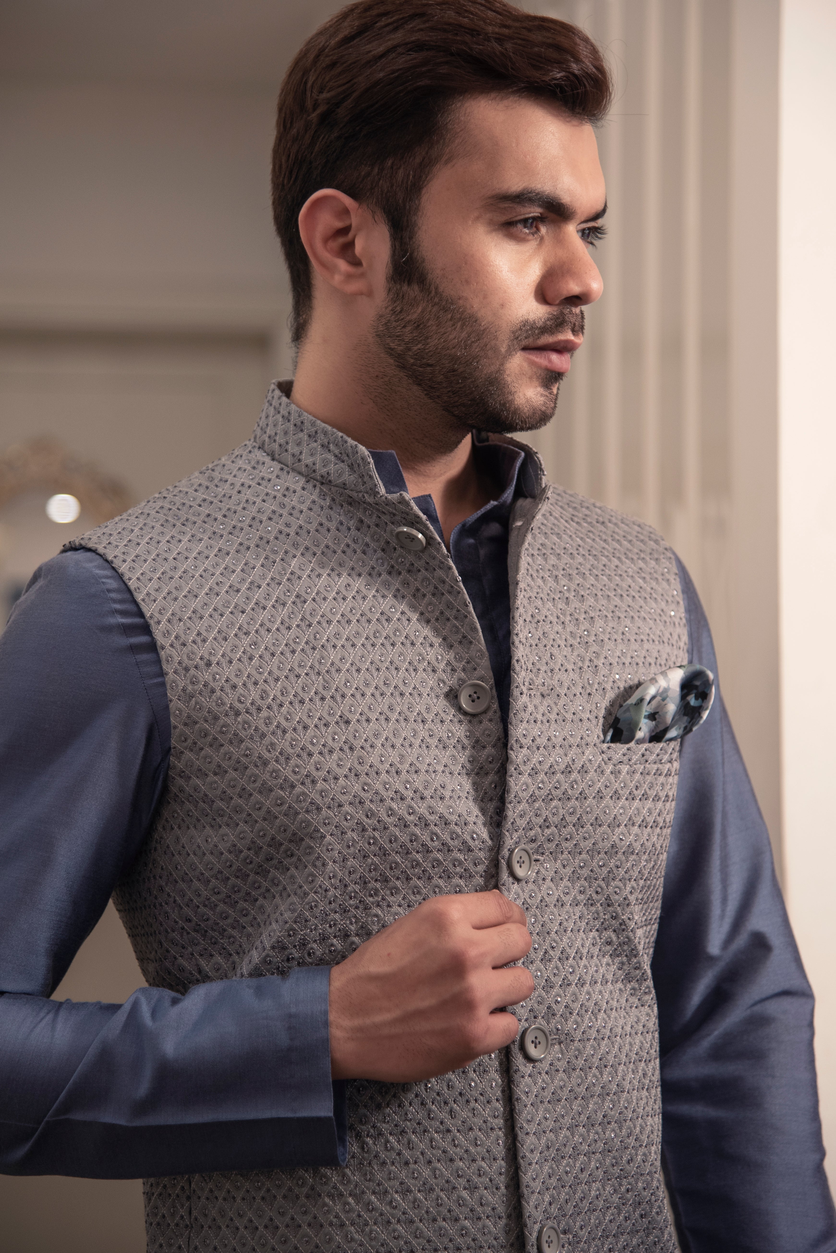 Grey embroidered nehru jacket paired up with blueish grey kurta and off white pajama.