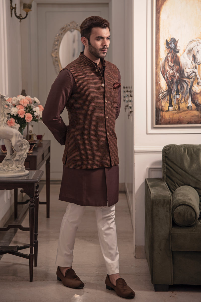 Brown quilted nehru jacket paired up with chocolate brown kurta and off white pajama.