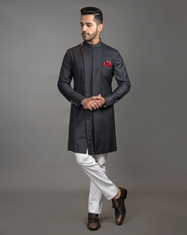 Black asymmetrical sherwani cut kurta with concealed buttons.  Paired up with off white pant cut pajama.